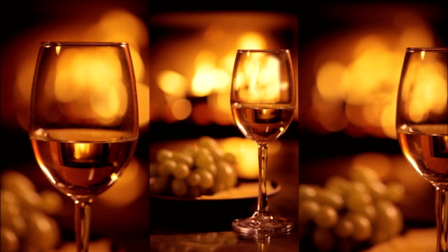 Vertical-videos-of-one-white-wine-wineglasses-over-fireplace-background.