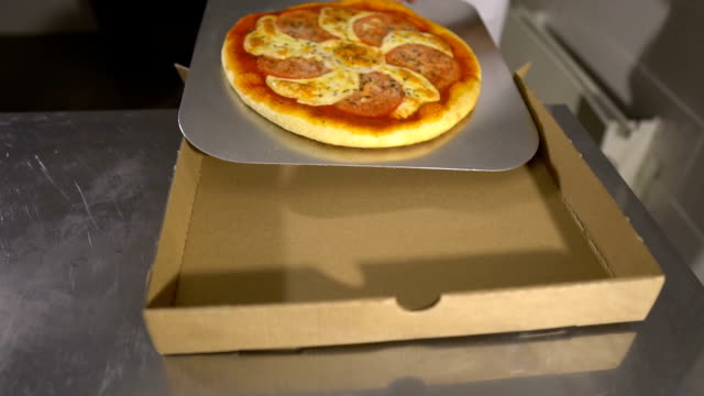 Pone-la-pizza-en-una-caja-de-cartón.-La-vista-desde-la-parte-superior.-Entrega-de-pizza.