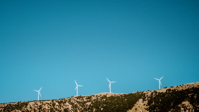 4-k-Zeitraffer-Windmühle-Turbinen-auf-Gebirge-gegen-strahlend-blauen-Himmel