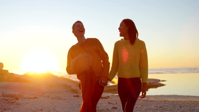 Couple-walking-hand-in-hand-on-the-beach-4k