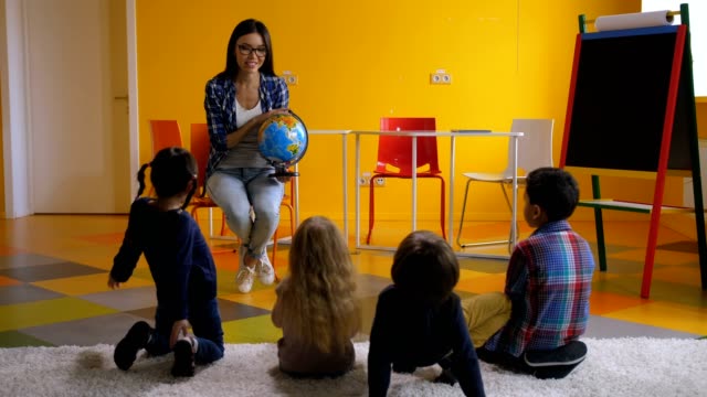 Preschool-teacher-teaching-kids-about-globe