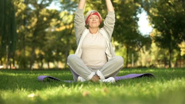 Middle-age-woman-deeply-breathing-and-meditating-sitting-in-lotus-position