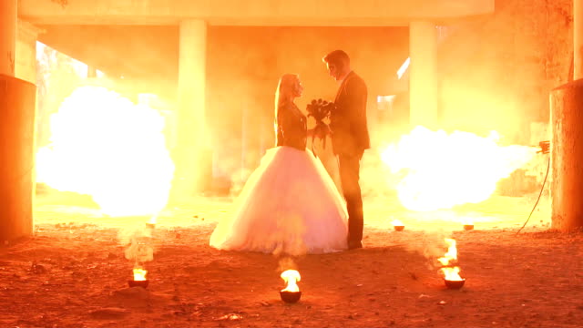 Couple-with-makeup-for-Halloween-at-a-party,-a-huge-fire-is-burning-nearby.