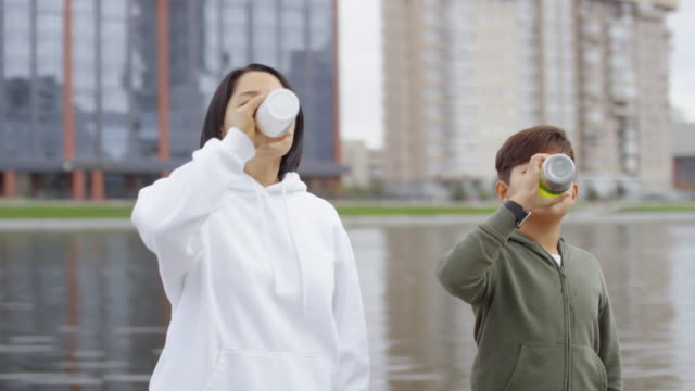 Asian-Mother-and-Son-Drinking-Water-and-Posing-for-Camera-after-Run