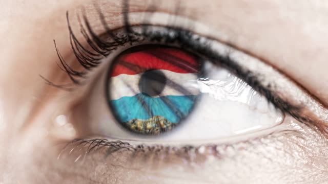 woman-green-eye-in-close-up-with-the-flag-of-Luxembourg-in-iris-with-wind-motion.-video-concept