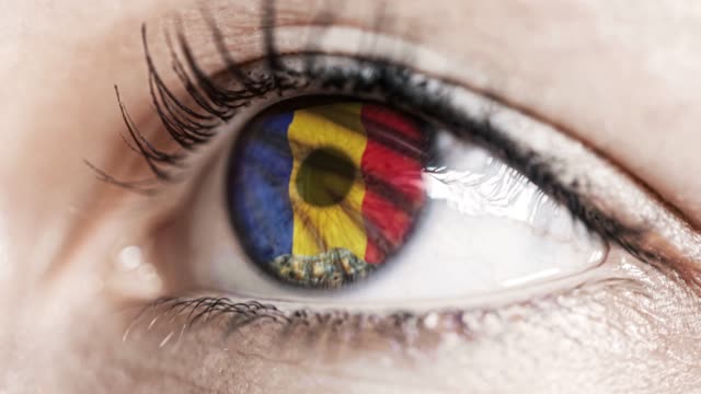 Frau-grünes-Auge-in-Nahaufnahme-mit-der-Flagge-von-Rumänien-in-Iris-mit-Windbewegung.-Videokonzept