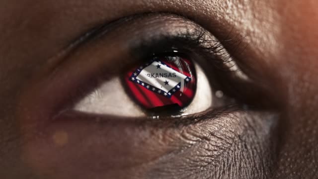 Mujer-ojo-negro-en-primer-plano-con-la-bandera-del-estado-de-Arkansas-en-iris,-estados-unidos-de-América-con-movimiento-de-viento.-concepto-de-vídeo