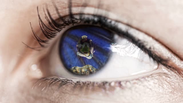 Mujer-ojo-verde-en-primer-plano-con-la-bandera-del-estado-de-Maine-en-iris,-estados-unidos-de-América-con-movimiento-de-viento.-concepto-de-vídeo