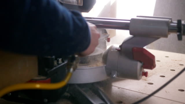man-using-air-compressor-system-to-blow-sawdust,-slow-motion