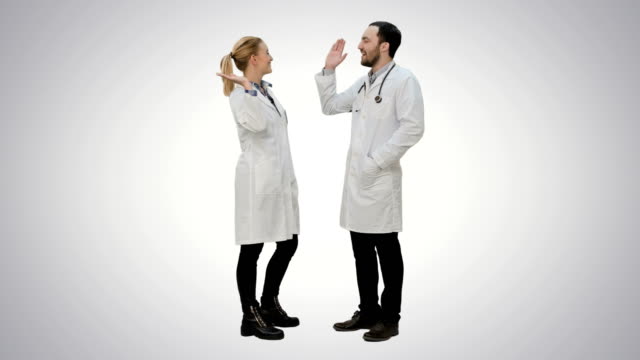 Ärztefreunde-geben-sich-gegenseitig-fünf-und-drücken-auf-weißem-Hintergrund
