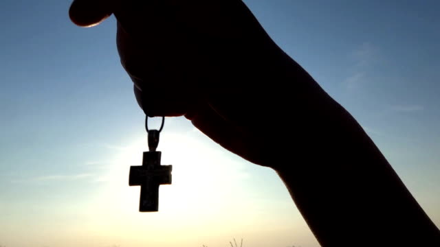 Closeup-Of-Silhouette-Cross-Hanging-at-sunset/sunrise-time