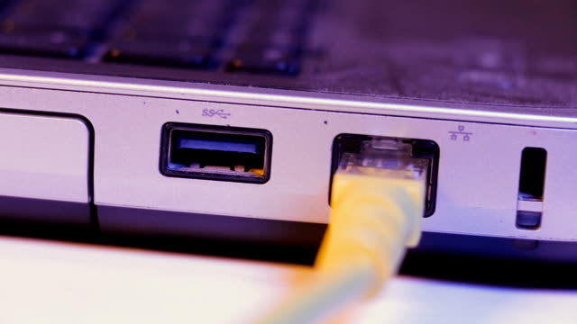 Closeup-of-Ethernet-cable-plug-inserted-into-port-on-the-side-of-a-laptop