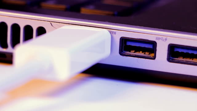 Closeup-de-HDMI-del-cable-de-enchufe-insertado-en-el-puerto-en-el-lado-de-un-ordenador-portátil