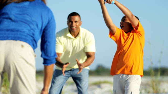 Gesunde-afroamerikanische-Familie-Baseball-zu-spielen,-am-Strand