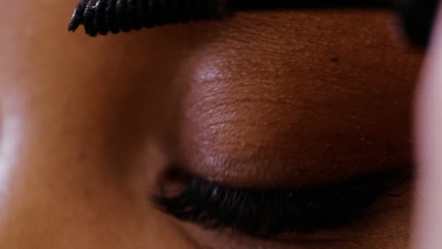 Close-up-makeup-artist-combing-eyebrows-after-painting-with-pencil-or-shadows