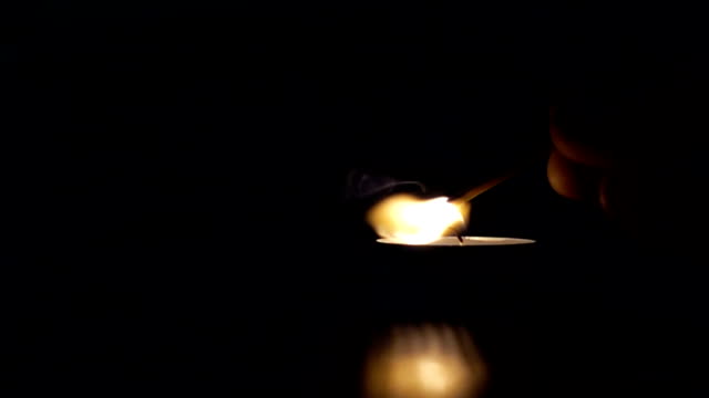 Lighting-a-match-stick-from-candle,-slow-motion