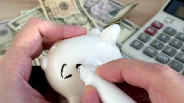 Savings-for-education.-Hands-writing-word-colledge-on-a-piggy-bank.