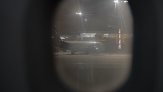 View-to-night-Sheremetyevo-Airport-from-illuminator-of-arrived-plane,-Moscow