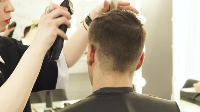 Haircutter-haciendo-el-pelo-hombre-corte-con-podadoras-de-pelo-y-peine-en-peluqueria-de-cerca.-Peluquería-haciendo-peinado-profesional-con-máquina-de-afeitar-eléctrica