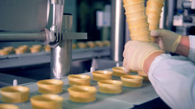 Fabrikarbeiter-setzt-Wafer-Tassen-in-einem-beweglichen-Förderband