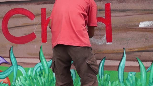 Pintor-mural-dibuja-la-letra-d-en-la-pared-de-la-escuela