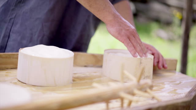 Herstellung-von-Käse.-Molkerei-Arbeiter-stellt-den-Käse-in-Formen.-Frischer-Käse