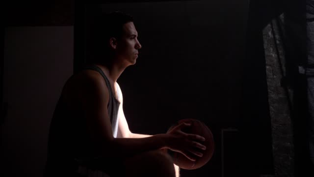 Basketball-player-sitting-and-waiting-for-game-to-start,-going-to-playground