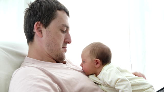 Loving-man-cuddling-with-newborn