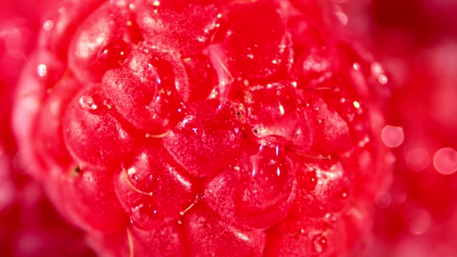 Macro-shot-drops-of-clear-transparent-water-falling-on-raspberry
