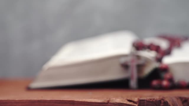 Biblia-y-el-crucifijo-granos-sobre-una-mesa-de-madera-rojo-Fondo-hermoso.-Concepto-de-la-religión-de-cerca