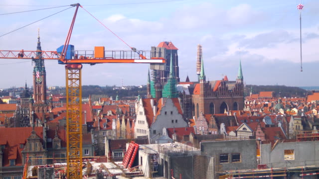 Vista-aérea-en-grúas-de-construcción-y-panorama-del-casco-antiguo-de-Gdansk-en-4-k-lenta-60fps