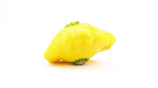 One-yellow-patisson-squash-with-water-drops.-Rotating-on-the-turntable.-Isolated-on-the-white-background.-Close-up.-Macro.