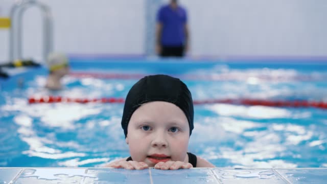 Schwimmkurse-für-Kinder-in-den-Pool---schönes-hellhäutige-Mädchen-im-Wasser-schwimmt