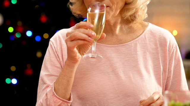 Alte-Frau-trinken-Champagner,-versucht-zu-Lächeln-in-die-Kamera,-einsamen-Witwe-verärgert