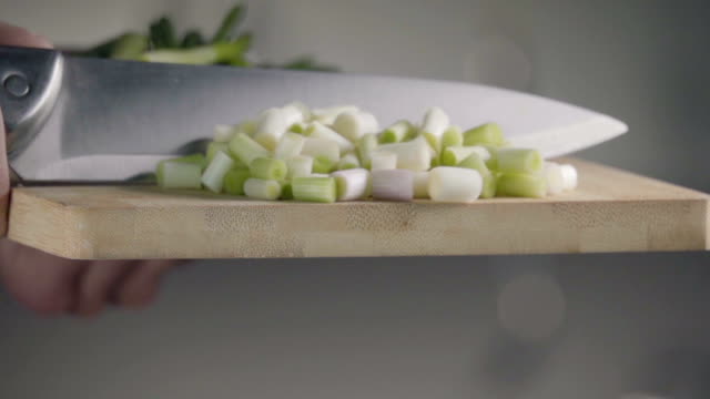 Falling-of-green-onion-into-the-frying-pan.-Slow-motion-240-fps