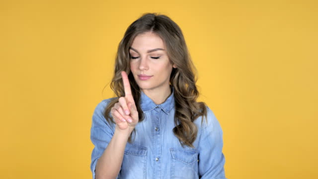 Young-Girl-Waving-Finger-to-Refuse-Isolated-on-Yellow-Background