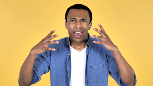 Screaming-Angry-Young-African-Man-Isolated-on-Yellow-Background