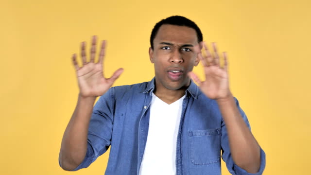 Young-African-Man-Confused-and-Scared-of-Problems-Isolated-on-Yellow-Background
