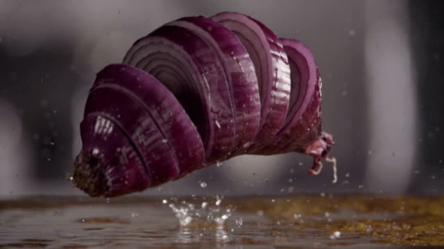 Falling-of-sliced-red-onion-into-the-wet-table.-Slow-motion-480-fps