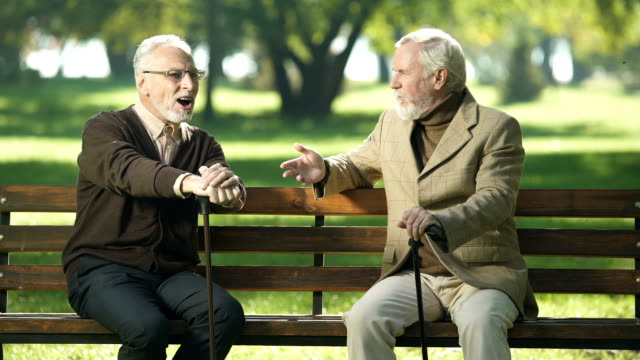 Senior-man-suffering-age-related-Alzheimer-disease,-old-friends-talking-in-park