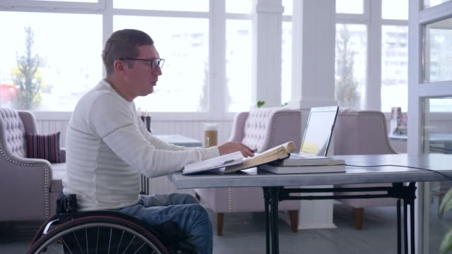 e-Business-von-Menschen-mit-Behinderungen,-erfolgreicher-Mann-brillentragende-auf-Rollstuhl-arbeiten-auf-smart-Laptop-Computer-während-remote-Betriebswirtschaft-deaktiviert