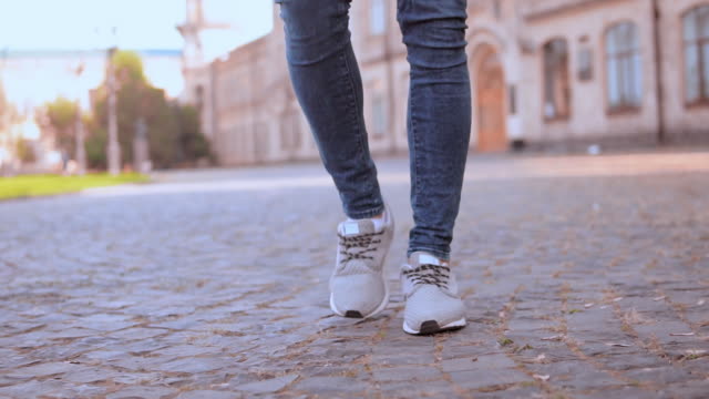 männliche-Beine-zu-Fuß-auf-dem-Bürgersteig