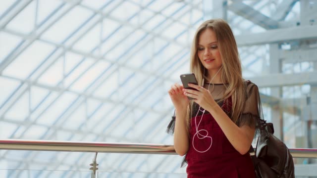 Mädchen-nutzen-Handy,-Unschärfe-in-der-Mall-als-Hintergrund-Bild