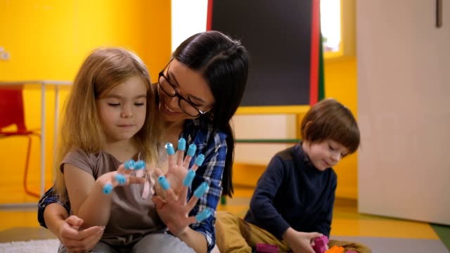 Preschool-teacher-and-girl-having-fun-with-toys