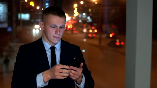 The-man-is-a-businessman-in-the-hands-of-a-smartphone,-looking-at-the-camera-and-angry,-trying-to-contain-anger.