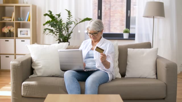 ältere-Frau-mit-Laptop-und-Kreditkarte-zu-Hause