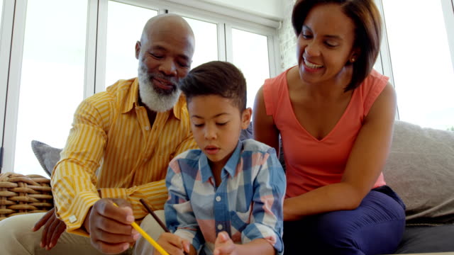 Vista-frontal-de-negro-padres-a-hijo-con-la-tarea-en-una-casa-confortable-4k