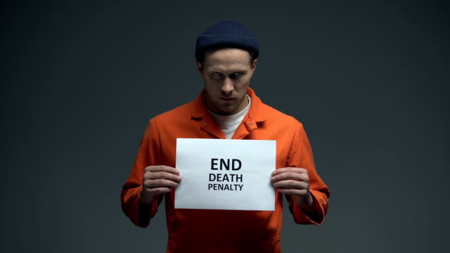 Kaukasischer-männlicher-Häftling-hält-Ende-Todesstrafe-Zeichen-in-Zelle,-um-Hilfe-zu-bitten
