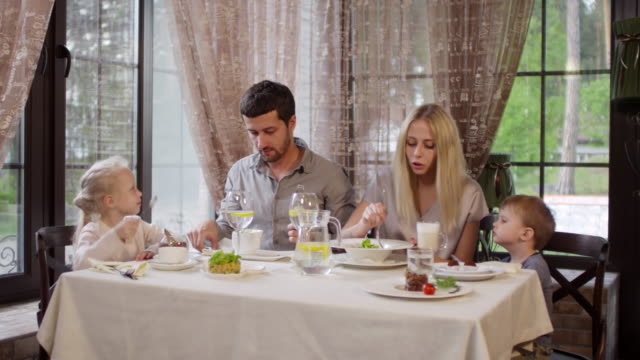 Family-of-Four-Eating-in-Restaurant