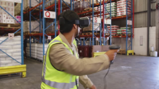 Männlicher-Lagerarbeiter-mit-VR-Headset-und-Controller-in-Laderaum-4k